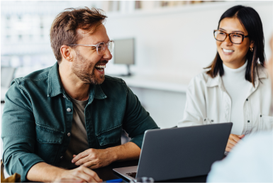 Businesspeople laugh and smile joyfully in a meeting room