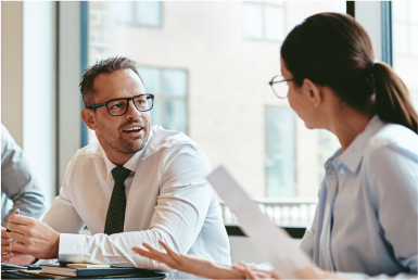 Colleagues converse in an office room