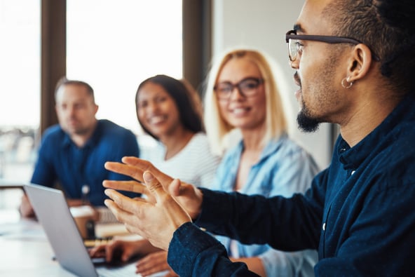 Four people at a conference table in discussion