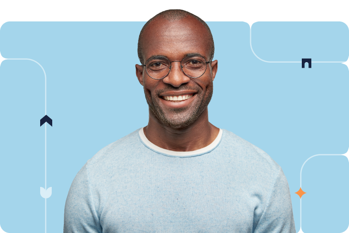 A man in glasses smiles against a blue background