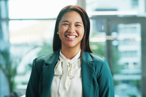 A young professional in a blazer smiles