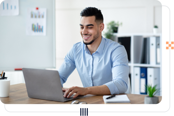 A businessperson smiling seated at a laptop