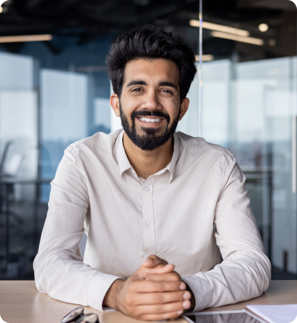 Businessperson at a modern office desk with hands folded on the table