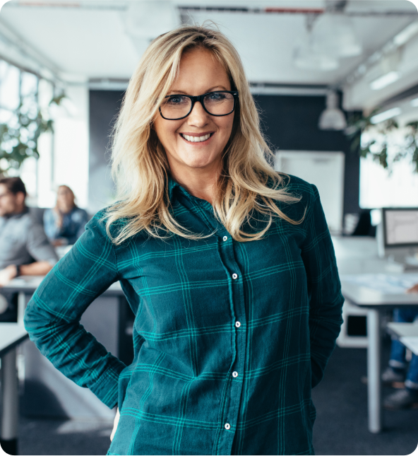 A person smiles standing in an office